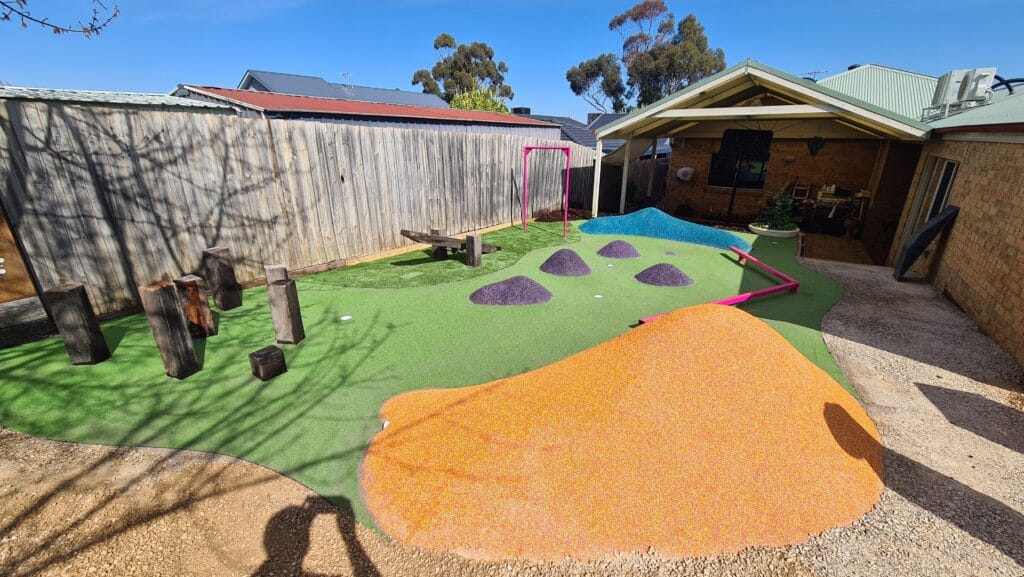 Outdoor sensory playscape with rubber climbing mounds and Corten steel screens